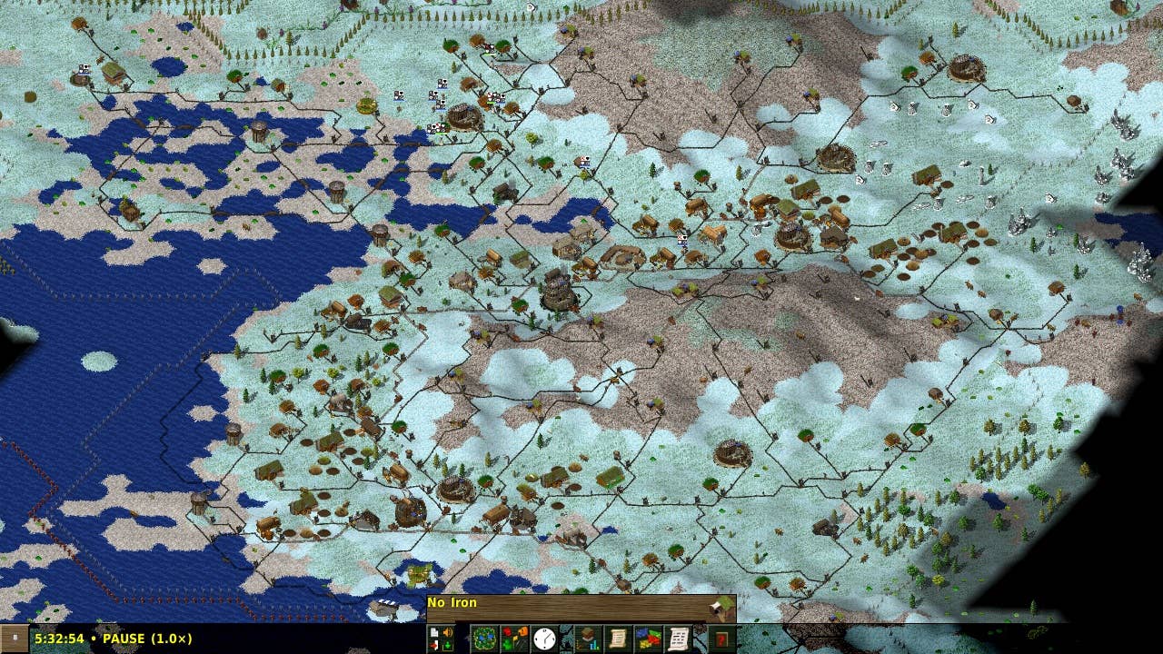 A zoomed-out view of snowy white terrain with visible ocean and homes built around the coast.